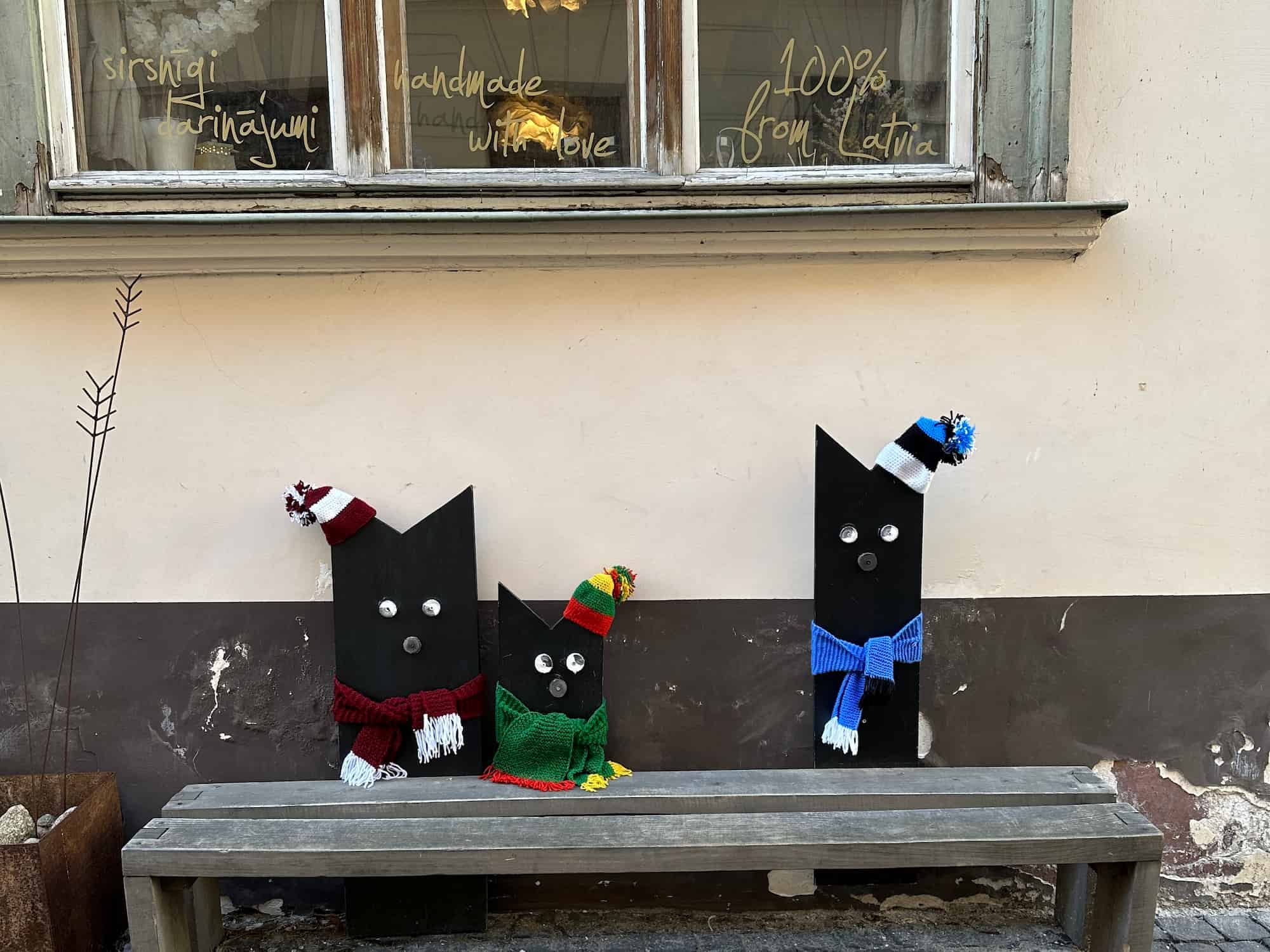 Handmade cats sitting on a bench