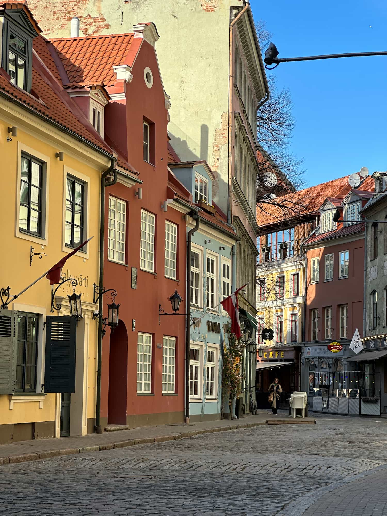 A random street in Old Riga with three buildings painted in different colours